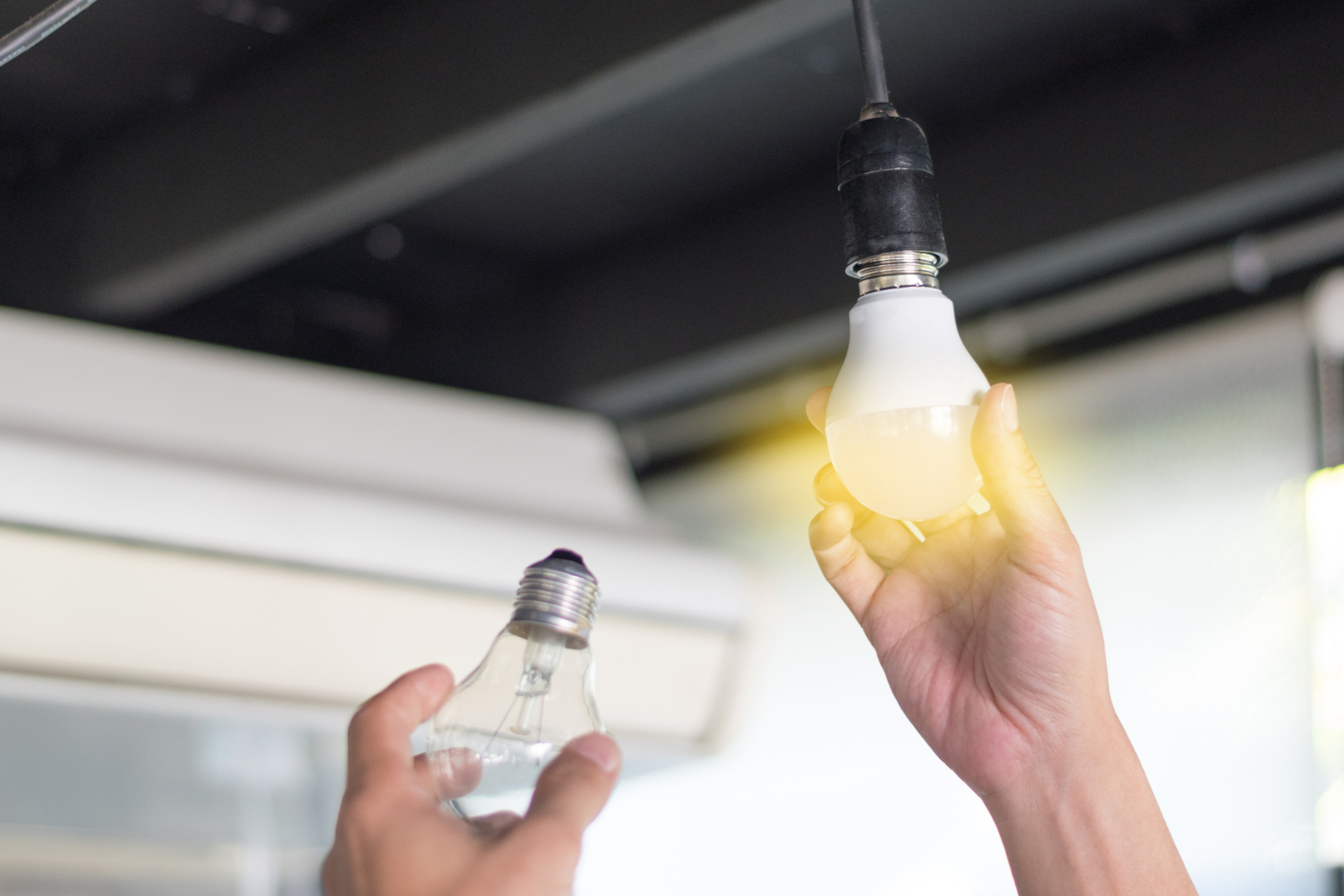 man changing lightbulb to LED lightbulb